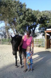 June Mitchell age 5 stands with her neighbor Margaret Hunter and Choco one of the horses injured during the attack on June 2.