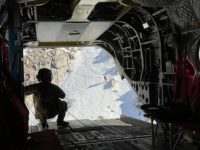 View looking out of Chinook helicopter towards deep gorge snow covered chute 1